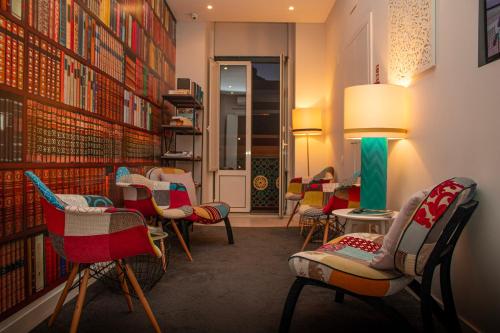 a waiting room with colorful chairs and books at Rio Art Hotel in Setúbal