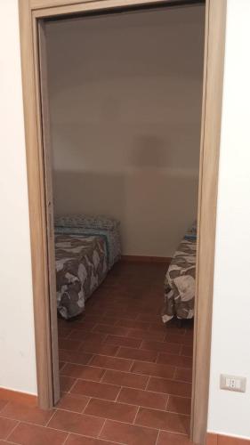 Habitación con 2 camas y puerta a un dormitorio en Rifugio nel borgo, en Monasterace