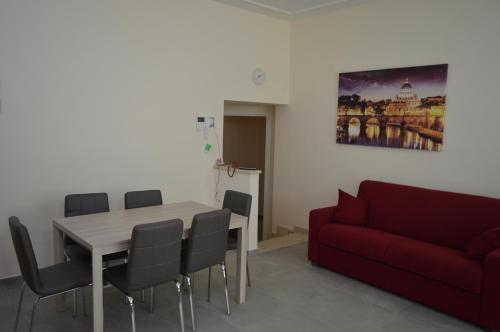 a living room with a table and a red couch at Bea&B in Rome