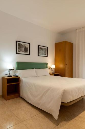 a bedroom with a large bed with a green headboard at Hostal Xic in Sant Pau de Seguries