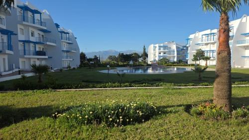 een park met een palmboom en gebouwen bij Appartement Riviera in Cabo Negro