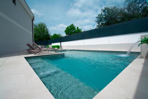 a swimming pool with two chairs and a fountain at Mi Casa in Vrdnik