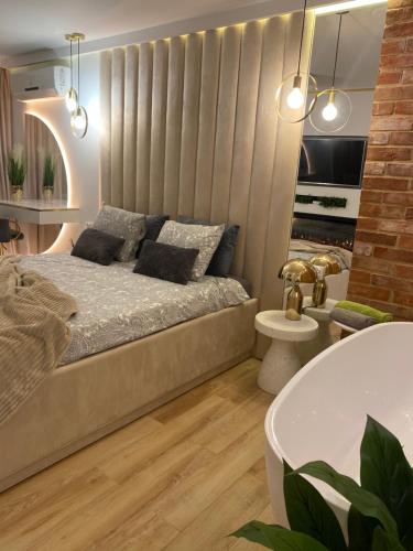 a bedroom with a bed and a bath tub at Apartament MoLoo I in Ostróda