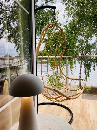 a rattan chair sitting in front of a window at Apartament MoLoo I in Ostróda