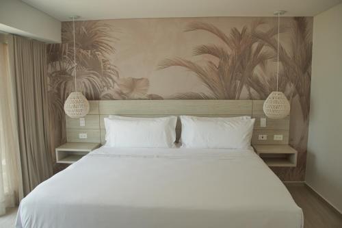 a bedroom with a large white bed with white pillows at Zafi Hotel in San Andrés