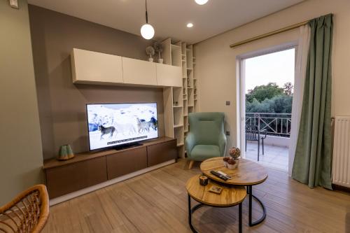 a living room with a flat screen tv and a table at My Nafpaktos Resort in Nafpaktos