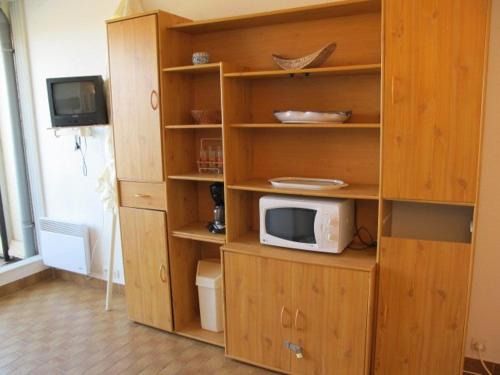 une étagère avec un four micro-ondes dans la cuisine dans l'établissement Studio Héliopolis AB 322 - 2 personnes, au Cap d'Agde