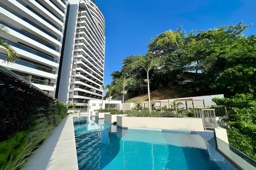a swimming pool next to a tall building at UNU 1108 Beach Class Ondina: Vista Mar, Piscina e+ in Salvador