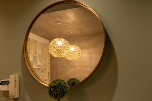 a mirror on a wall with a chandelier at My Nafpaktos Resort in Nafpaktos