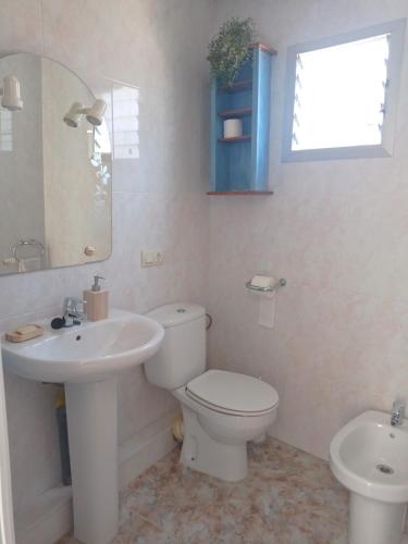 a bathroom with a white toilet and a sink at Casa Ermita in Benifallet