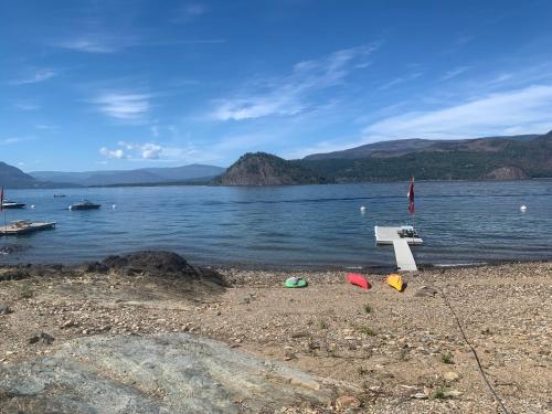 a bench on the shore of a body of water at West facing Waterfront Retreat with private beach, dock access & private buoy in Blind Bay
