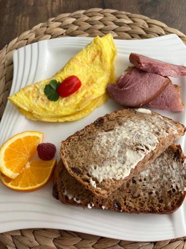 a plate of breakfast food with eggs ham and toast at Serenity on the Lake in Niagara on the Lake