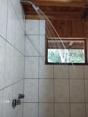 a shower with a stream of water in a bathroom at Casa Cucuya in Puerto Quito