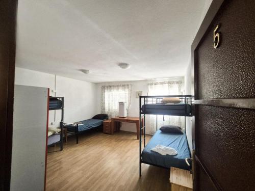 a dorm room with bunk beds and a desk at Hostel Hakuna Matata in Dubrovnik