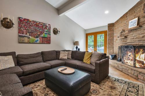 a living room with a brown couch and a brick wall at Hearth & Timber in Bridgman