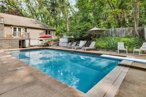 a swimming pool in a yard with chairs and an umbrella at Hearth & Timber in Bridgman