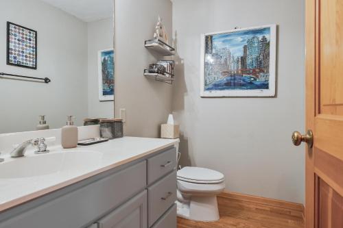 a white bathroom with a toilet and a sink at Hearth & Timber in Bridgman