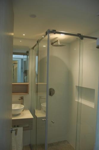 a bathroom with a glass shower and a sink at Zafi Hotel in San Andrés