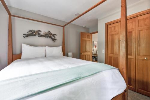 a bedroom with a large white bed with a wooden headboard at Hearth & Timber in Bridgman