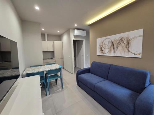 Una sala de estar con un sofá azul y una mesa. en Vulcano Apartments, en Cirò Marina