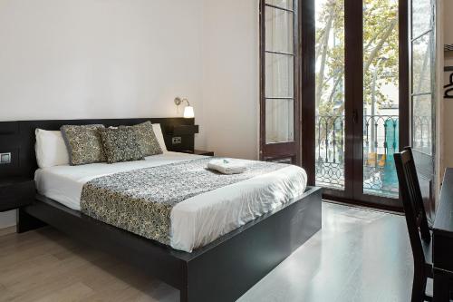 1 dormitorio con 1 cama y balcón en BruStar Gotic-Centric, en Barcelona