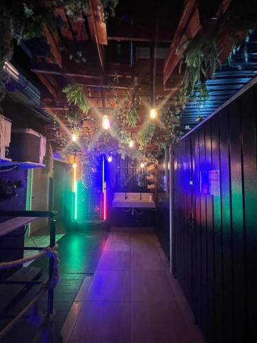 a dark room with purple and green lights at Esquina 8 Suítes Confort & Hostel in Florianópolis