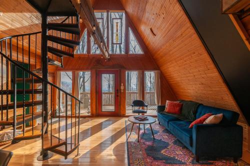 a living room with a blue couch and a staircase at Honeycomb Hideaway by AvantStay Rustic Retreat in Fairview