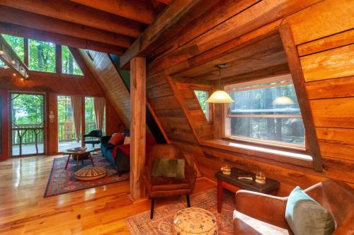 a living room with wooden walls and a ceiling with windows at Honeycomb Hideaway by AvantStay Rustic Retreat in Fairview