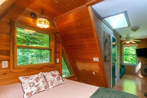 a bedroom with wooden walls and a bed with pillows at Honeycomb Hideaway by AvantStay Rustic Retreat in Fairview