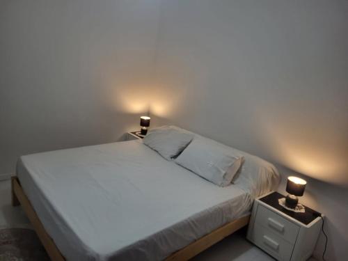 a bedroom with a bed with two lights on it at family apartment in Tizi Ouzou