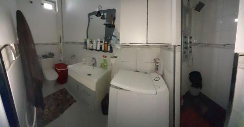 a small bathroom with a toilet and a sink at family apartment in Tizi Ouzou