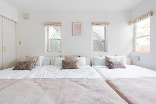 a white room with two large beds in it at Luxury Tokyo Stay I 120sqm 4LDK I Close to Shibuya & Shinjuku Area in Tokyo