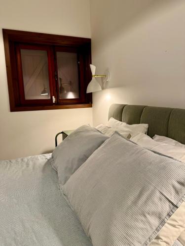 a bedroom with a large bed with two windows at Quintinha da Oliveira in Marco de Canavezes
