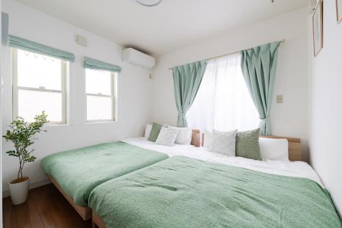 two beds in a bedroom with green and white at Luxury Tokyo Stay I 120sqm 4LDK I Close to Shibuya & Shinjuku Area in Tokyo