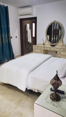 a bedroom with a large white bed and a dresser at Villa relax todo verde natural in Almuñécar