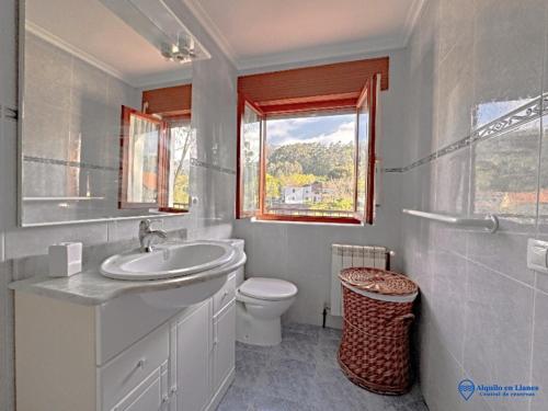 a bathroom with a sink and a toilet and a window at Cuetu el Tornu in Puertas