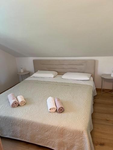 two pairs of slippers sitting on a bed at Apartman Kalac in Korčula