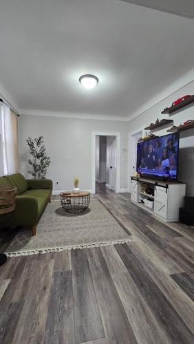 a living room with a green couch and a tv at Serenity Haven in Irvington