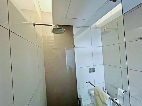 a bathroom with a shower with a glass door at Stunning City View Apartment Sandton City-The Capital On The Park in Johannesburg