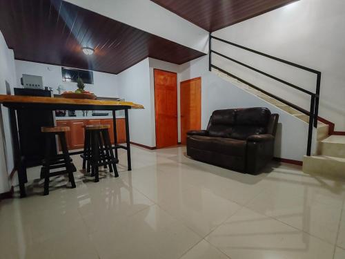 a living room with a couch and a table and stairs at Apartamento Lantanas in Parrita