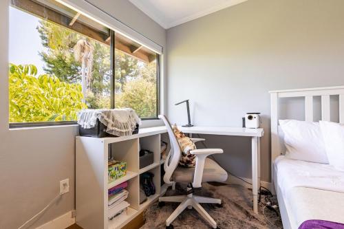 a bedroom with a desk and a bed and a window at Los Angeles - Centrally located between Disneyland Universal Studios Beverly Hills and Downtown LA Most ideal city to stay with stunning views and heated pool in Hacienda Heights