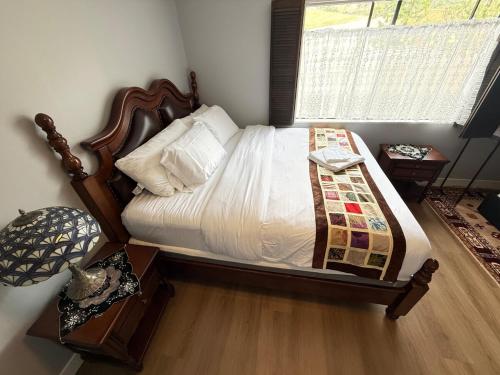 a bedroom with a bed with a wooden headboard and a window at Los Angeles - Centrally located between Disneyland Universal Studios Beverly Hills and Downtown LA Most ideal city to stay with stunning views and heated pool in Hacienda Heights