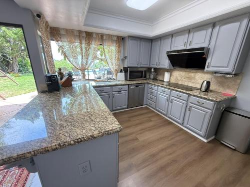 a kitchen with white cabinets and granite counter tops at Los Angeles - Centrally located between Disneyland Universal Studios Beverly Hills and Downtown LA Most ideal city to stay with stunning views and heated pool in Hacienda Heights