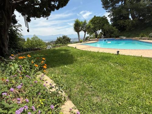 a swimming pool in a field of grass with flowers at Los Angeles - Centrally located between Disneyland Universal Studios Beverly Hills and Downtown LA Most ideal city to stay with stunning views and heated pool in Hacienda Heights