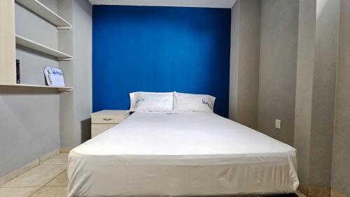 a bed in a room with a blue wall at Sensity Home Habitación 5 A Cómoda y calida con baño compartido in Tehuacán