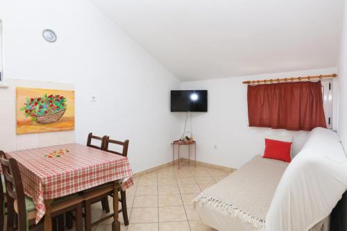 a room with a table and a bed and a table and chair at Apartments by the sea Grebastica, Sibenik - 4881 in Bašelovići