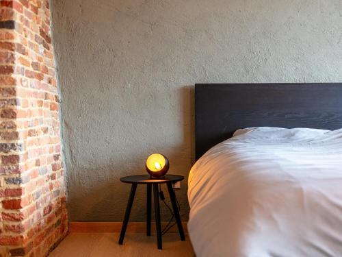 a bedroom with a bed and a lamp on a table at Alverwege 2 in Baerle Heide