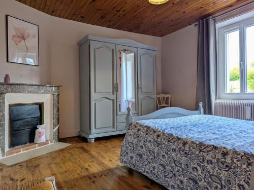Saint-Just-près-BrioudeにあるMaison de caractère avec jardin, idéale famille, près de Brioude, prox. baignade et ski - FR-1-582-314のベッドと暖炉のある寝室