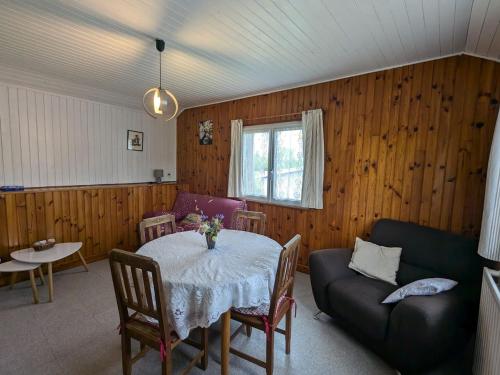 un salon avec une table et un canapé dans l'établissement Gîte reposant en forêt avec terrasse, proche de Plombières-les-Bains - FR-1-589-165, à Le Val-dʼAjol