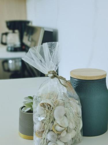 a plastic bag filled with shells sitting next to a cup at Our Paradise - Jaco Apartment in Jacó